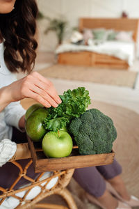 Midsection of woman holding fruits at home