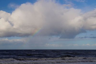 Scenic view of sea against rainbow in sky