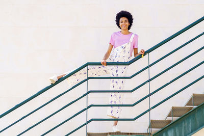 Portrait of young woman standing on staircase