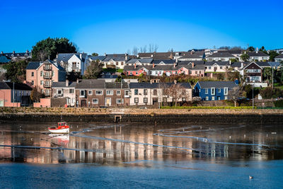 Houses in town against clear blue sky