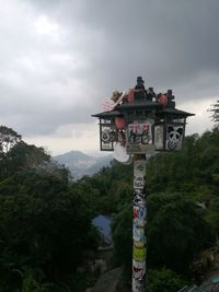 Information sign against trees and mountains against sky