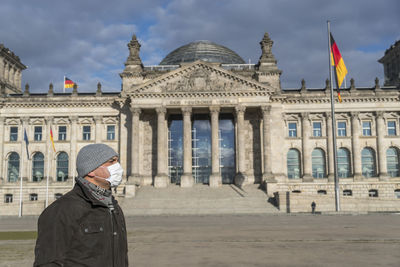 Man standing in front of historical building