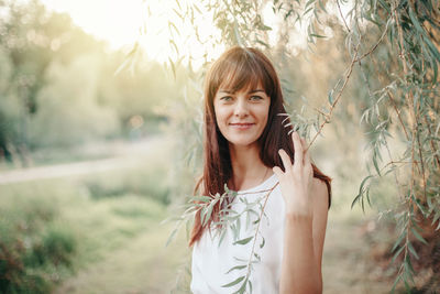 Portrait of smiling woman by tree
