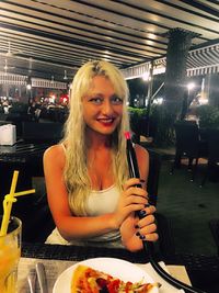 Portrait of young woman sitting in restaurant