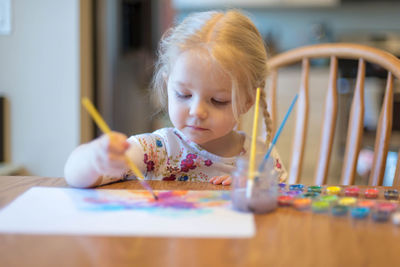 Close-up of girl making face on table