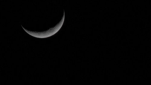 Low angle view of half moon against clear sky at night