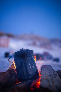 Close-up of bonfire against clear blue sky