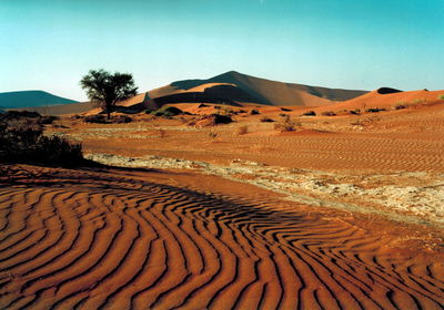 Scenic view of desert against blue sky