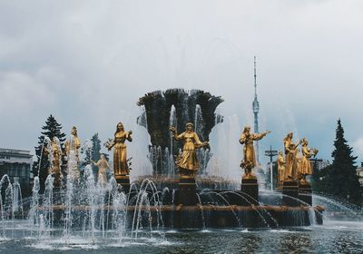 Gold statues at druzhba narodov against sky