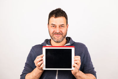 Portrait of man holding smart phone against white background