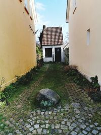 Footpath amidst buildings against sky