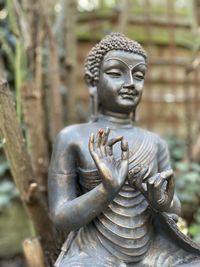 Close-up of buddha statue against wooden wall