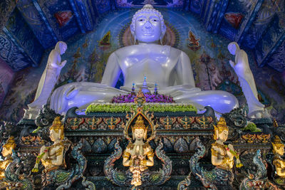 Low angle view of buddha statue against building