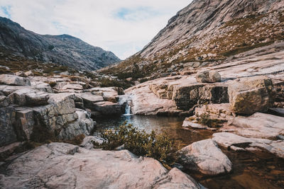 Scenic view of lake and rocks against sky