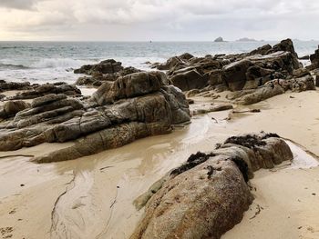 Scenic view of rocks on beach against sky