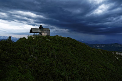 Building by mountain against sky