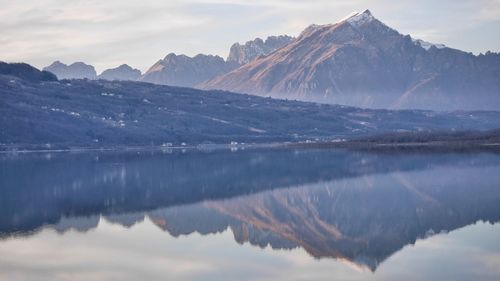 Scenic view of lake and snowcapped mountains against sky