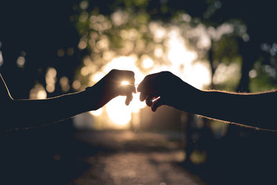 Silhouette of couple's hands outdoors