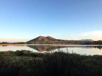 Scenic view of lake against clear blue sky