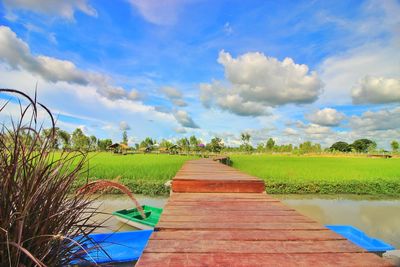 Footpath amidst field against sky