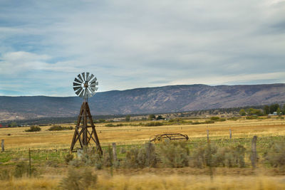 Windmill on field against sky