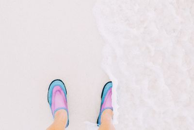Low section of person standing on sand