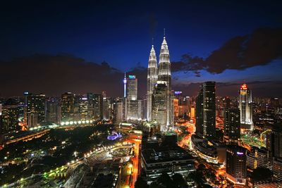 Illuminated cityscape against sky at night