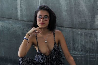 Portrait of young woman against wall