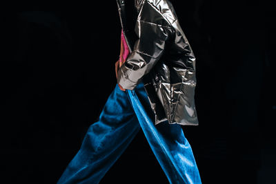 Low section of woman wearing scarf against black background