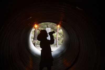 Silhouette of woman standing in tunnel