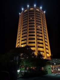 Low angle view of illuminated buildings against sky at night