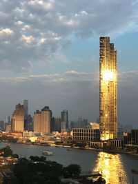 Modern buildings by bay against sky