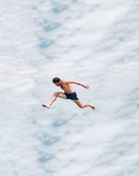 Low angle view of fit young man jumping to the sky