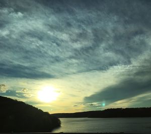 Scenic view of sea against cloudy sky at sunset