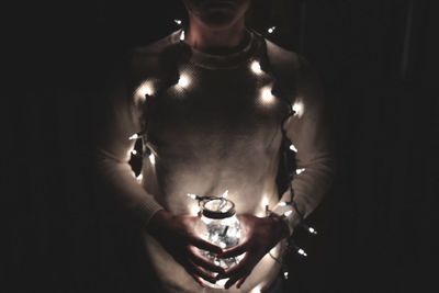 Close-up of human hand on illuminated lighting equipment