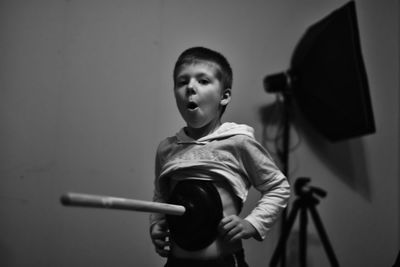 Playful boy with plunger at home
