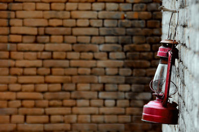 Close-up of lantern hanging on brick wall