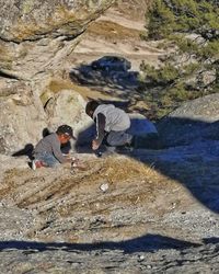 People walking on rocks against mountain