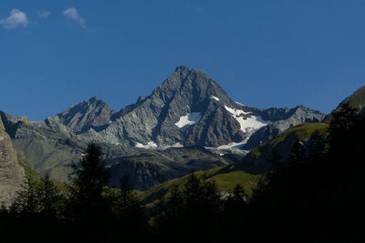 Scenic view of mountains against blue sky