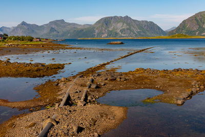 Installation of concrete pipeline submerged in water on the stone beach