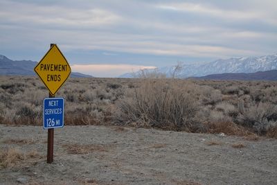 Road sign in death valley national park - pavement ends - next service 126 miles