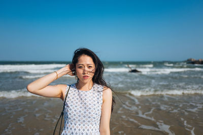 Portrait of woman standing at beach