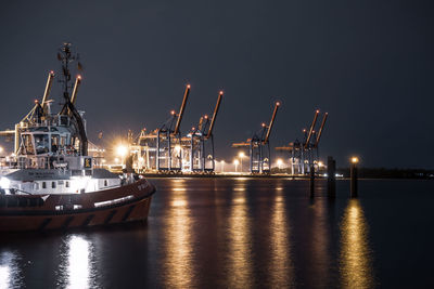 Illuminated commercial dock against sky at night