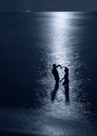 High angle view of silhouette people walking at beach