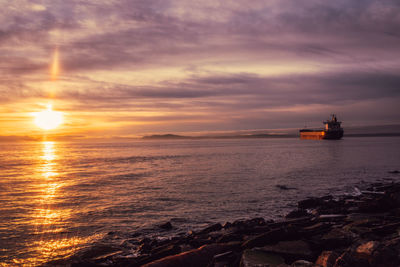 Empty cargo vessel in puget sound at sunset as viewed from centennial park