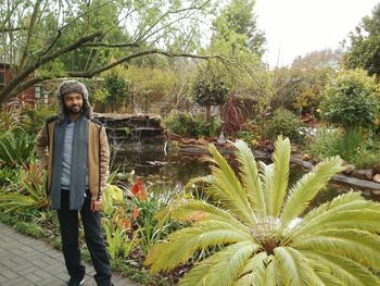 Full length of man wearing fur hat and jacket standing at park