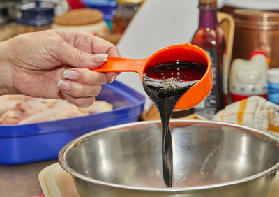 Chef pours soybean oil and teriyaki sauce into the chicken leg marinade bowl