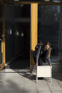 Female real estate agent keeping placard at entrance of apartment