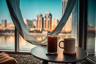 Close-up of drink on table against buildings in city