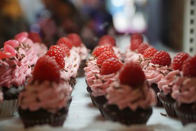 Close-up of muffins with raspberries arranged in row
